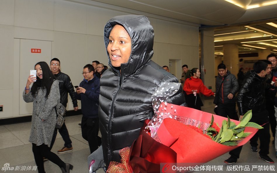 在球迷的簇拥下，玛雅·摩尔推着满载行李的推车走出机场，脸上依然挂着温柔而感激的笑容，仿佛一场盛大的欢迎仪式。