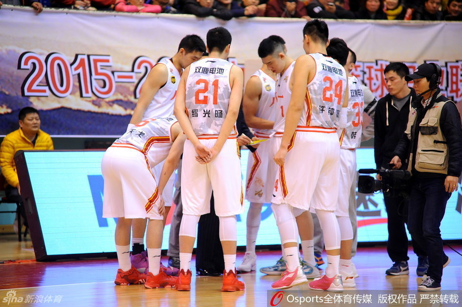 首发队员准备上场，五名先发球员神色凛然地站在中圈附近，他们身后巨大的八一军旗图案仿佛在燃烧，映照着勇士们无畏的脸庞。