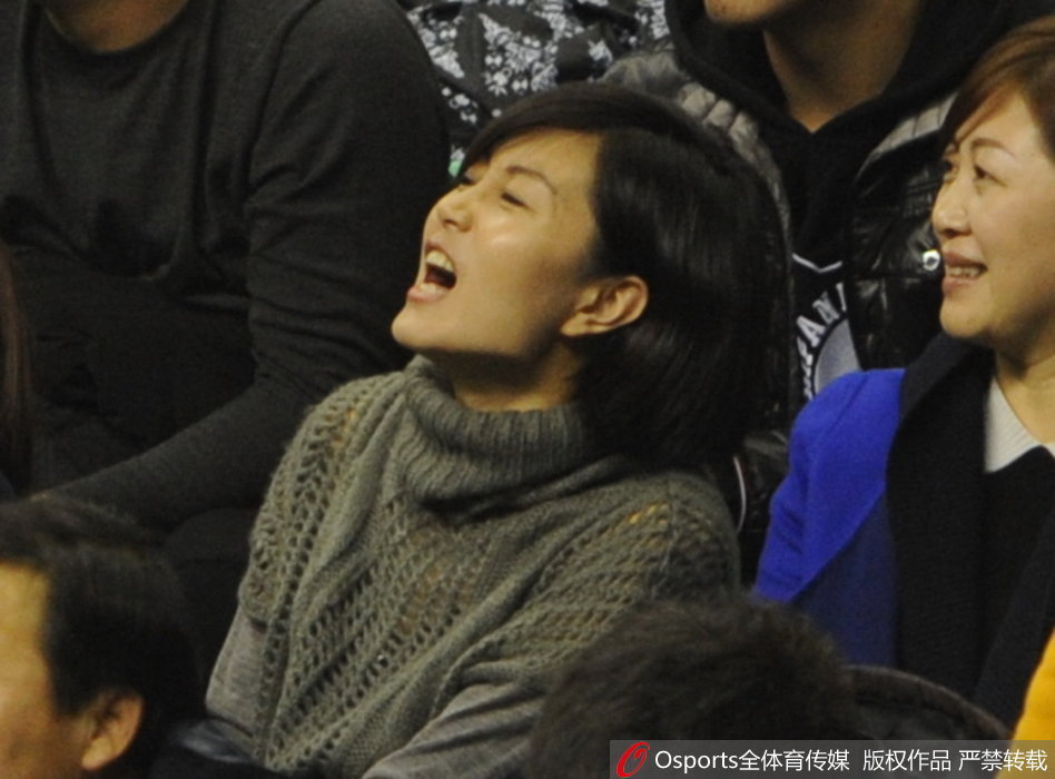 唐佳良兴奋地指向场内，似乎在告诉身边的伙伴：“快看，我看到他了！”那是一种无法掩饰的自豪与喜悦，仿佛整个球馆的灯光都汇聚于此。