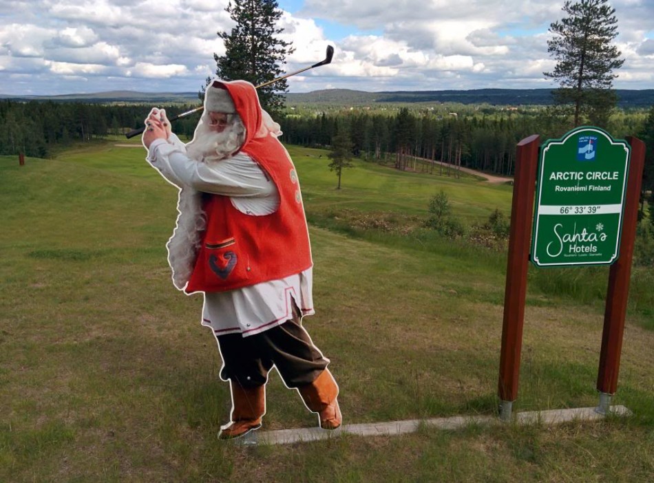 一位女士正开心地将一顶红色的圣诞帽戴在身旁球友的头上，球场边洋溢着温馨友爱的节日情谊。