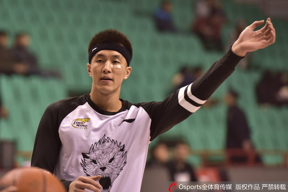 眼神坚毅的郭艾伦正在整理头上的发带，脸颊上的创可贴清晰可见，专注的神情透露出他对比赛的渴望。