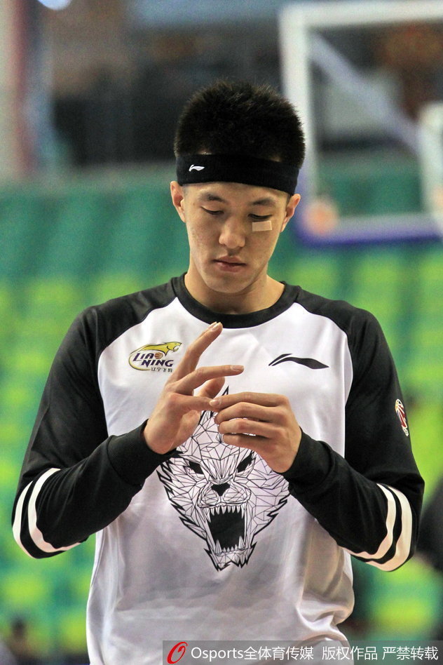 郭艾伦与队友击掌相互鼓励，赛前的热身氛围轻松而又充满斗志，他脸上的创可贴在灯光下格外醒目。