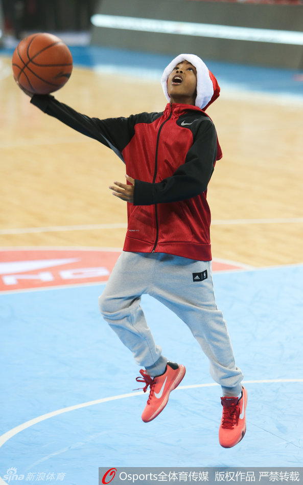 小马布里在空荡的球场看台前练习运球，他身着休闲卫衣，低头专注地控制着篮球，步伐灵动，举手投足间流露出与其年龄不符的成熟篮球技艺。