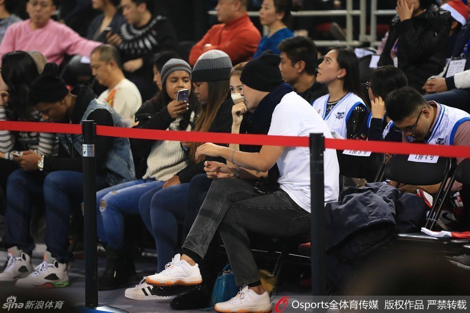 陈露戴口罩低头查看手机，却难掩出众气质，休闲打扮在人群中显得简约而不简单。