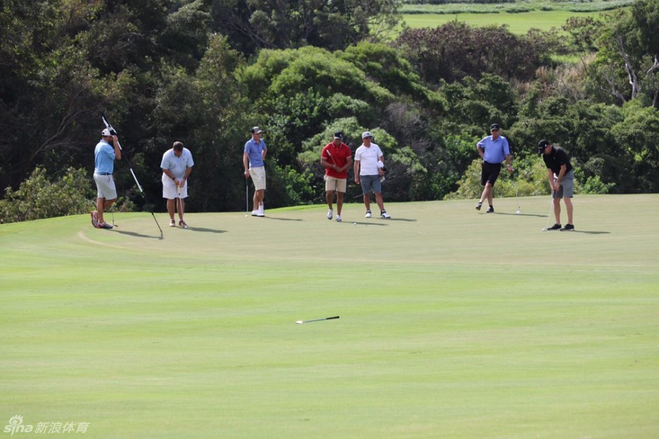 球员在果岭上专注推杆练习，黄昏的暖光为草地镀上金边，一片宁静致远
