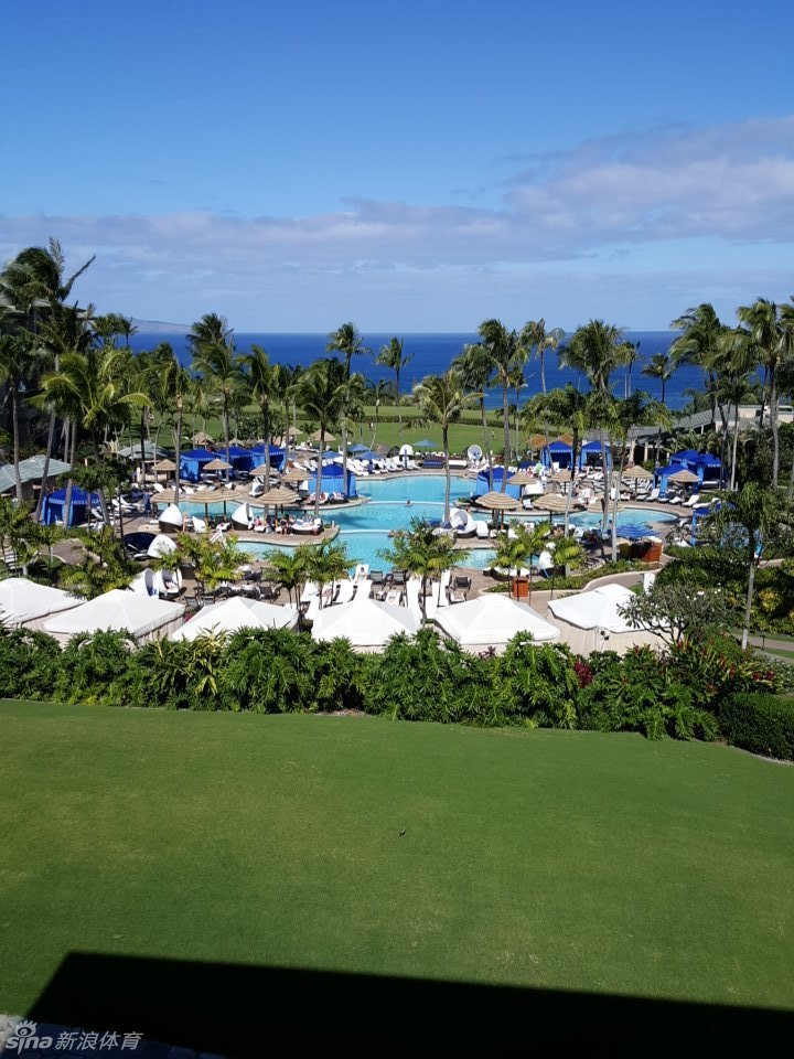 巴巴·沃森牵着儿子漫步于球场果岭边，父与子的温馨背影映衬在黄昏柔光中