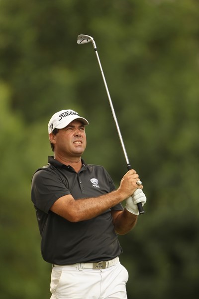 老将凯斯-霍恩在果岭边专注地观察推杆线路，他手扶球杆，微微蹙眉，不放过任何可能影响小球滚动的细微起伏。