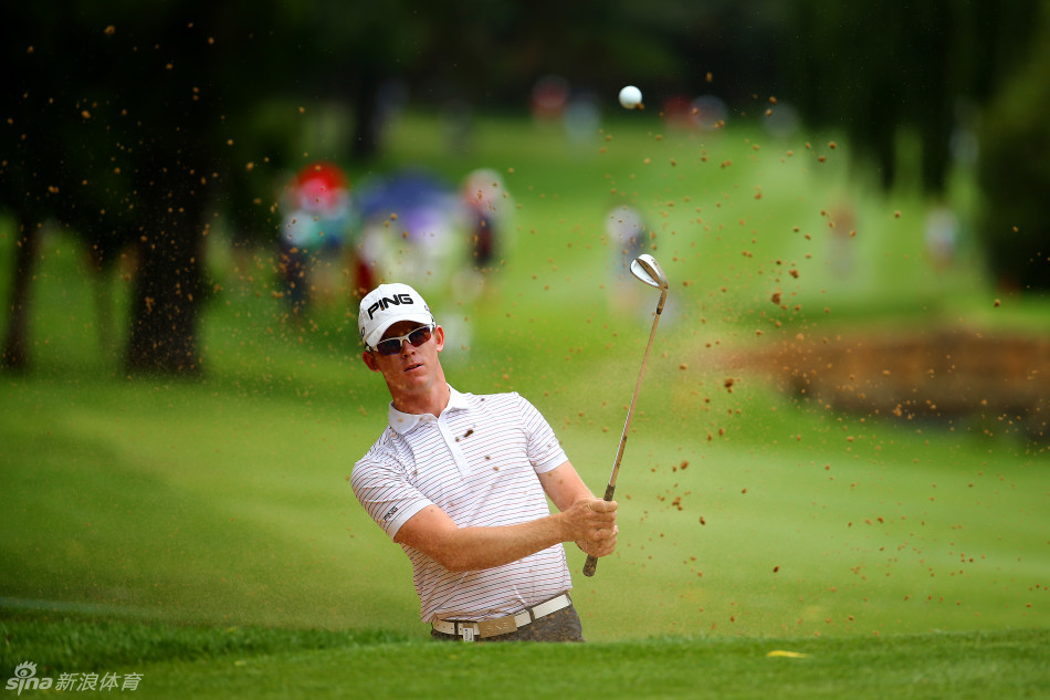 传奇名将厄尼-埃尔斯全神贯注,在果岭边进行精准的切杆评估,目光如炬审视球路