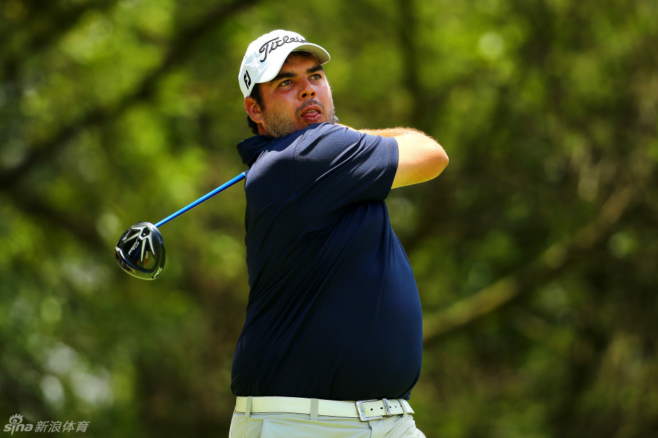 一位球员面对复杂的长草球位陷入沉思,手扶球杆姿态凝重,脚下是严峻的挑战