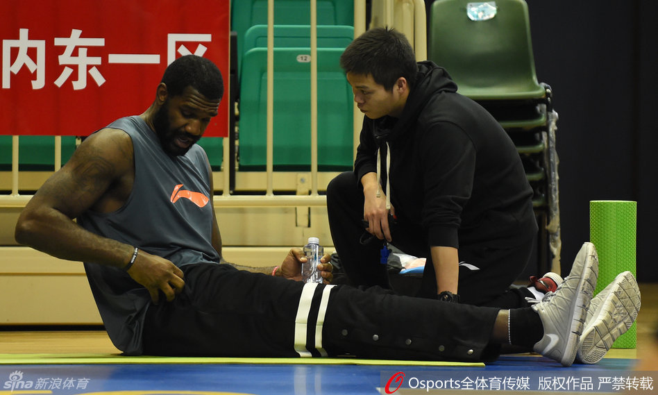 热身间隙，北控队的外援查尔斯利用短暂休息时间调整呼吸，坚定的目光望向前方，肌肉线条在灯光下清晰可见，力量感十足。