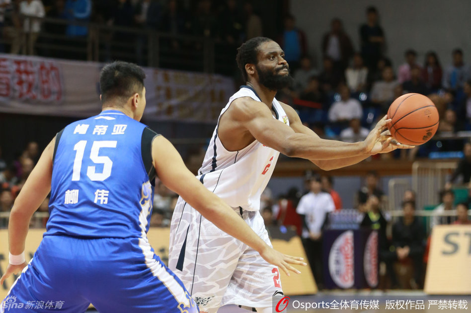 江苏队长易立在防守端拼尽全力，紧紧贴防广东队持球队员，眼神中透露出不屈的斗志，防守动作非常硬朗。
