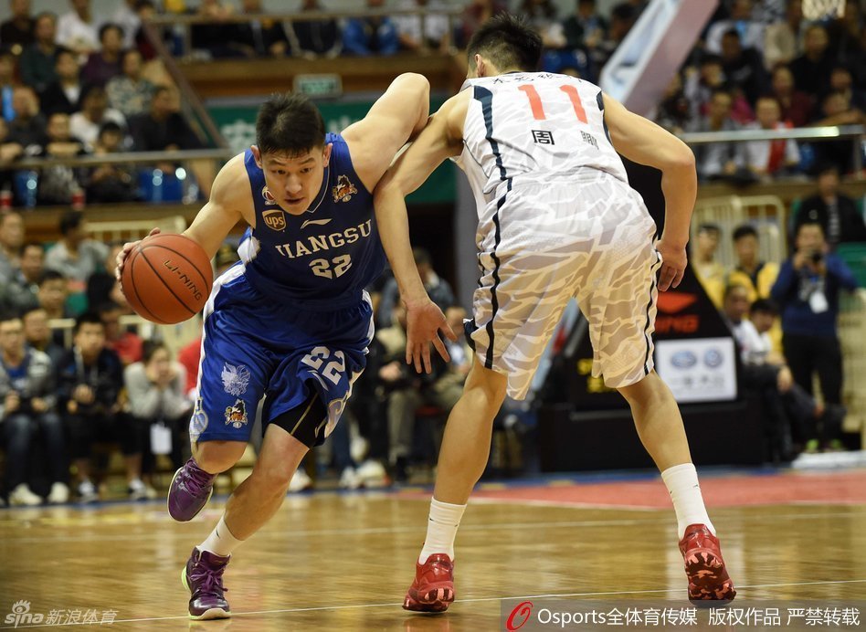 易建联在拼抢中意外扭伤脚腕，痛苦倒地，队友周鹏神情焦急地蹲在身边查看情况，场边担架已准备就绪。