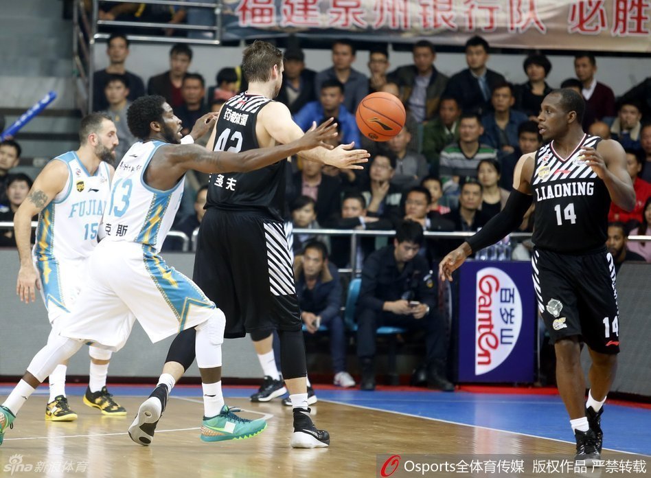 郭士强在场边双手合十，神情专注地指挥比赛，背后是沸腾的球迷看台，他的背影显得坚定而执着。