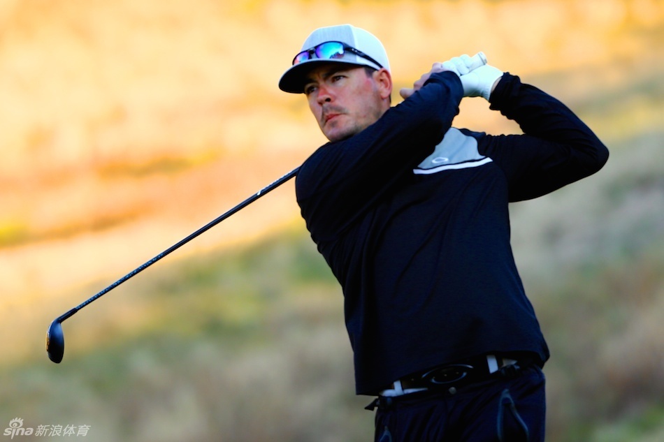 澳大利亚选手马克-莱奇在果岭边细心观察推击线路，他单膝跪地，神情专注地分析着草纹与坡度