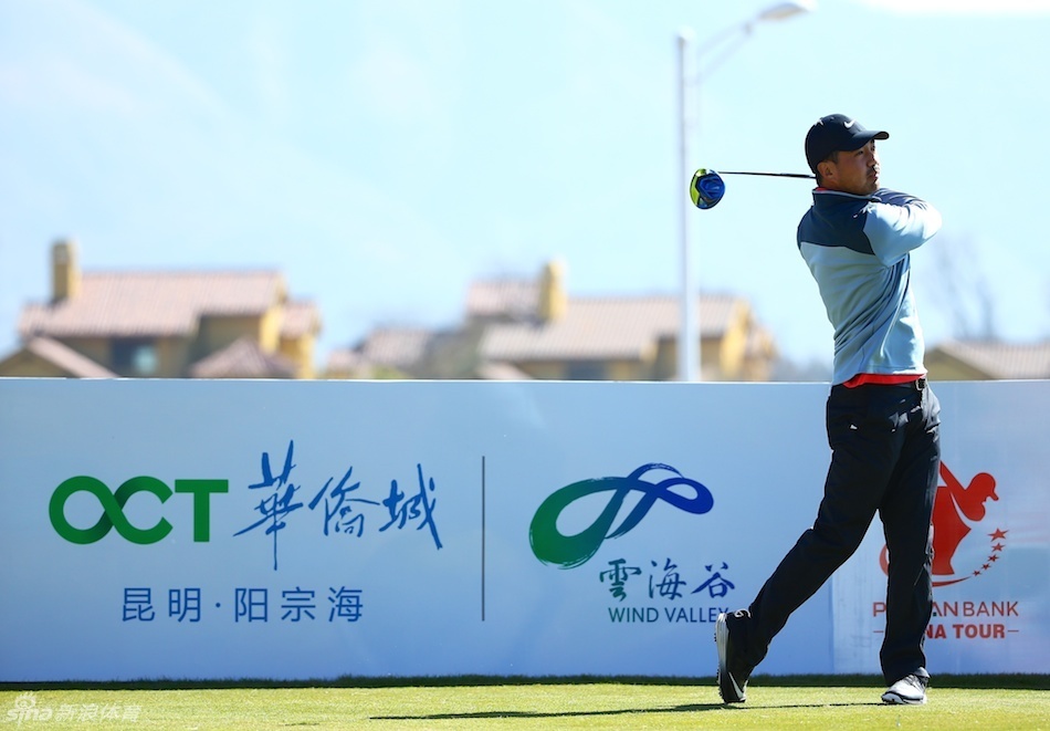 赛事举办地昆明阳宗海雷海谷球场的壮丽全景，蓝天白云下球场绿意盎然，水障与沙坑点缀其间