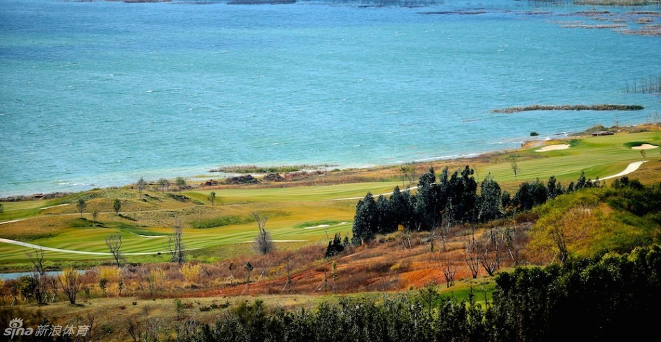 晨曦中的云海谷球场，球道如绿色绸带铺展在阳宗海畔，远山层峦叠嶂，宛若仙境