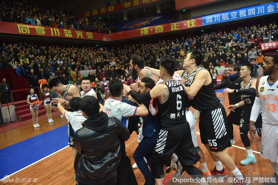 当值裁判神情严肃站在中央，用力分开纠缠在一起的双方球员