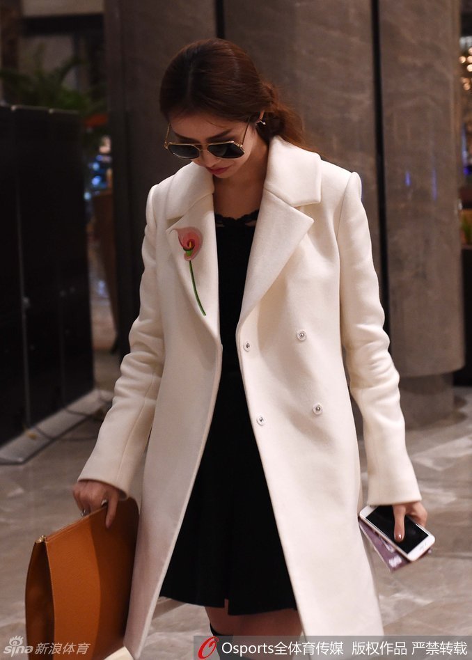 陈露身着一袭简约的深色冬装现身酒店大堂，高挑的身材在人群中格外醒目，她一边低头查看手机，一边稳步前行，周身散发着从容的时尚气息。