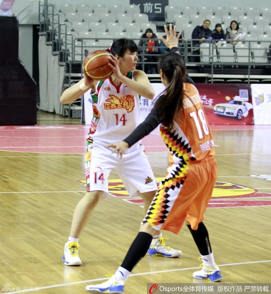 裁判员在全神贯注地观察场上局势，手势果断利落，白皙的脸庞在赛场灯光下显得格外英气逼人。