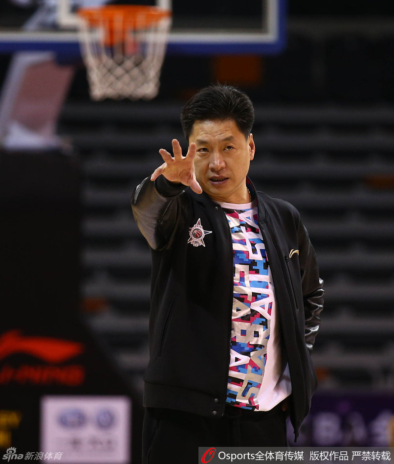 南区队主教练李春江在训练中神情严肃地指导队员，对战术细节要求极高，尽显冠军教头风范。