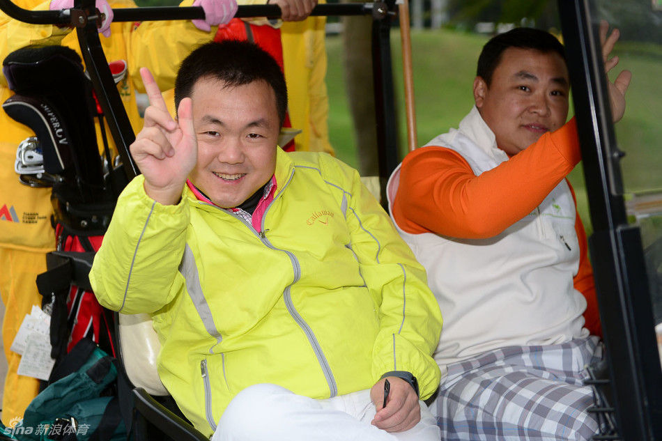 小白球在空中划出优美抛物线，背景是辽阔的蓝天与连绵绿茵