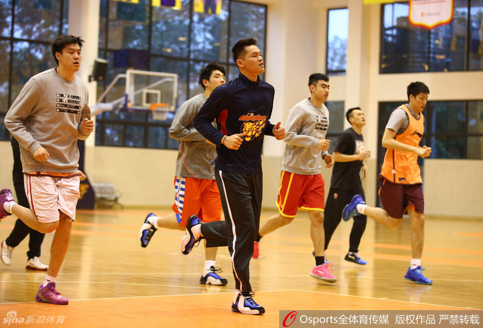 广东男篮众将绕场慢跑热身，步伐轻盈而整齐，场馆内回响着规律的脚步声，仿佛一曲斗志昂扬的序曲。
