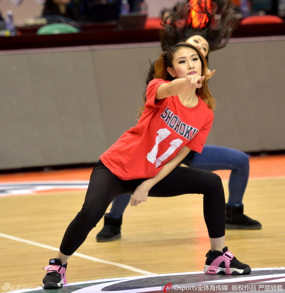 动感舞姿火力全开，姑娘们手持花球整齐划一，修长身姿在球场灯光下划出优美弧线。