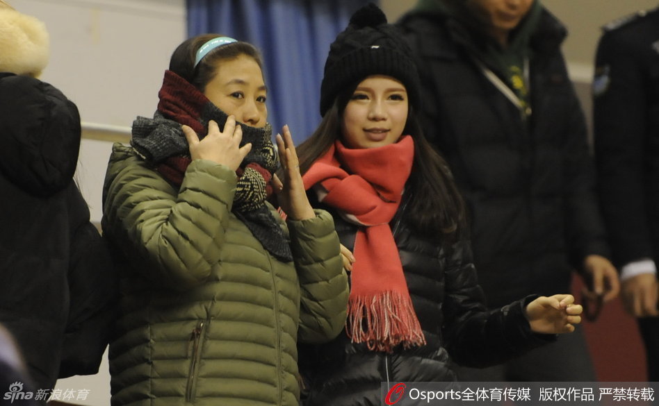 郭艾伦女友王俪婷身着便装坐在看台上，眼神专注地望向场内，嘴角带着浅浅的笑意，仿佛在用目光传递着无声的鼓励与支持。