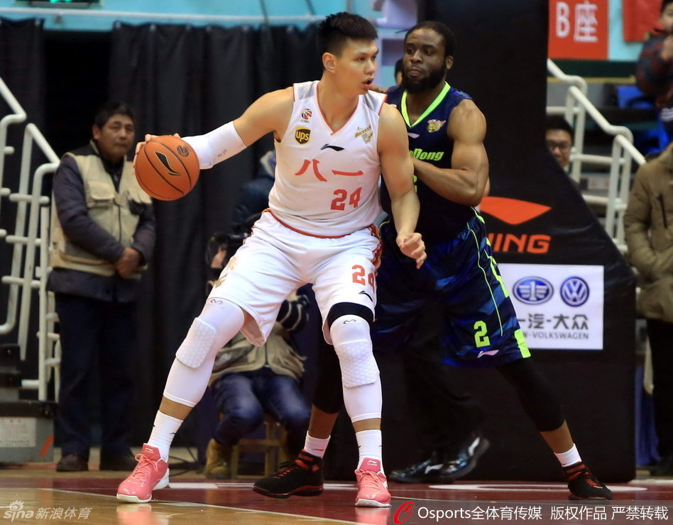 广东队队长周鹏弯下腰重心压得极低，手臂张开死死卡住八一队突破的路线，眼神如鹰隼般锐利地盯着对手的一举一动。