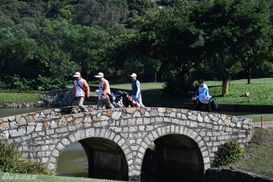 比赛现场，选手在发球台开球，观众在远处安静观看，气氛紧张而专注。