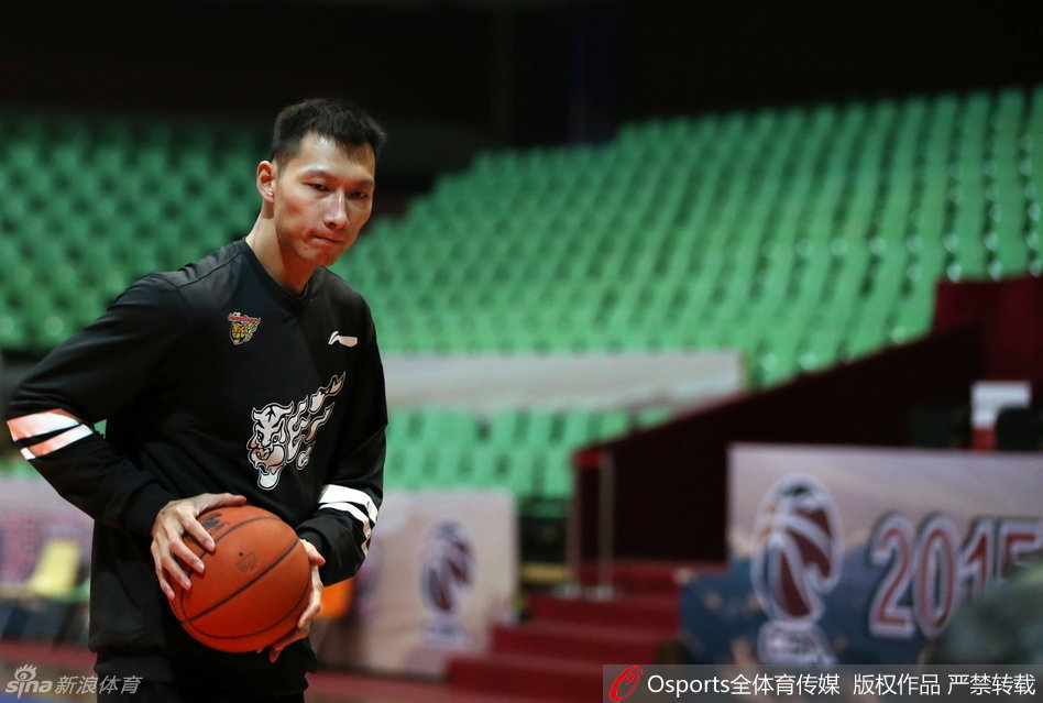 易建联拉伸时肌肉线条分明，神情专注而放松，他正利用弹力带进行肩背肌群拉伸，这套动作能有效预防高强度训练带来的损伤。