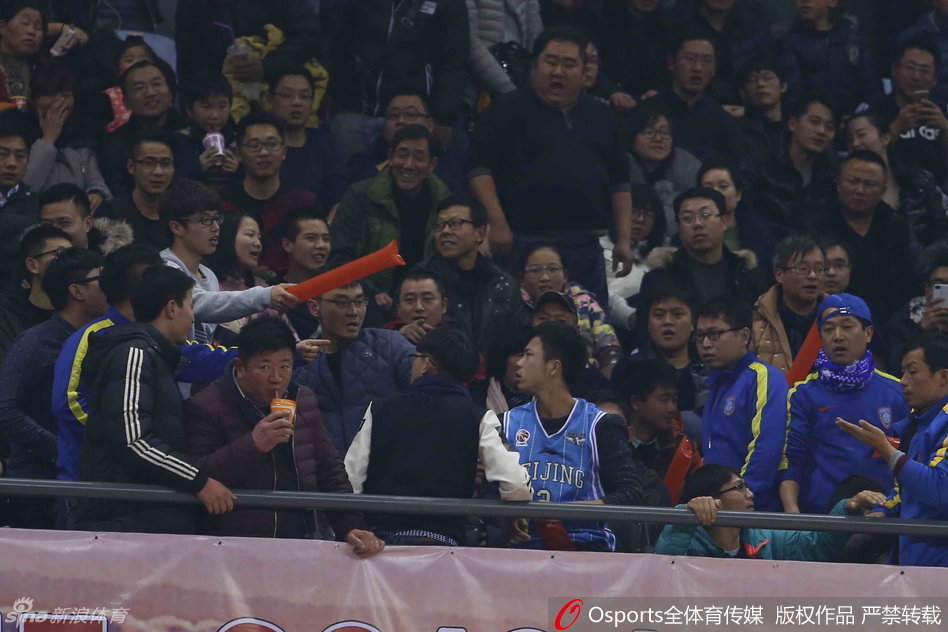 多名球迷在座椅间扭打成一团，有人被推倒在台阶上，安保人员奋力挤进人群，张开双臂试图分开双方，但冲突仍在持续