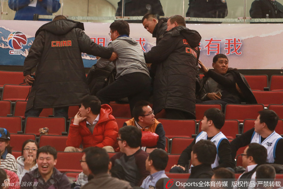 在安保人员的强力介入和护送下，几名涉事球迷被带离座位区，准备离开看台。周围的观众神情各异，有的仍在激动地议论，有的则流露出失望与无奈。场馆内明亮的灯光，似乎也无法驱散这紧张凝固的空气。