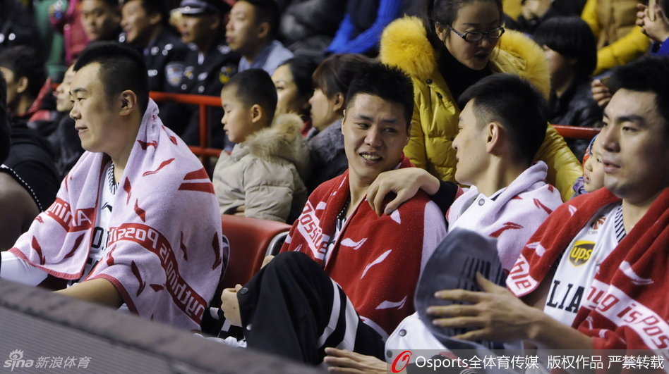 郭士强在场边拿着战术板，神情严肃地为球员讲解战术