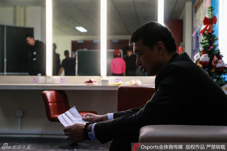 场边的孙悦虽然因伤未能出场，但他依然心系战局，穿着便服低头刷着手机，似乎在查找着什么信息，或许是想从数据中为场上的兄弟们找到一丝破解困局的线索。