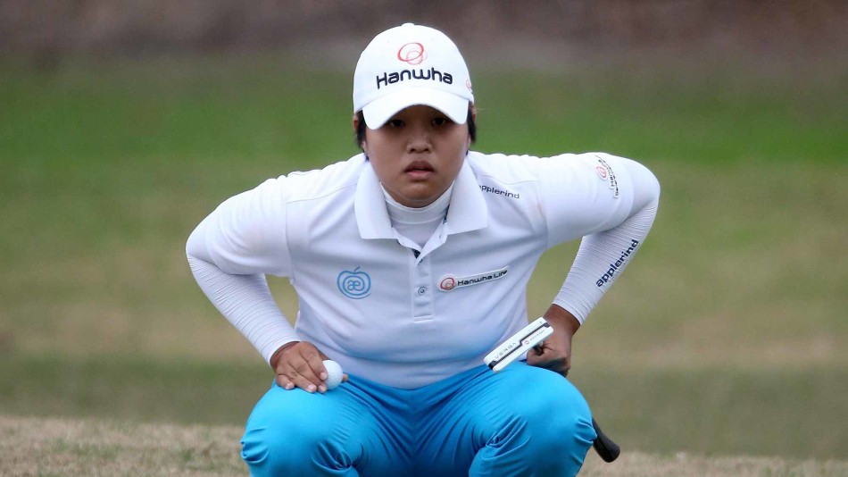 魏圣美完成一记漂亮的铁杆击球，身体充分扭转，眼神紧随小白球飞向果岭目标。