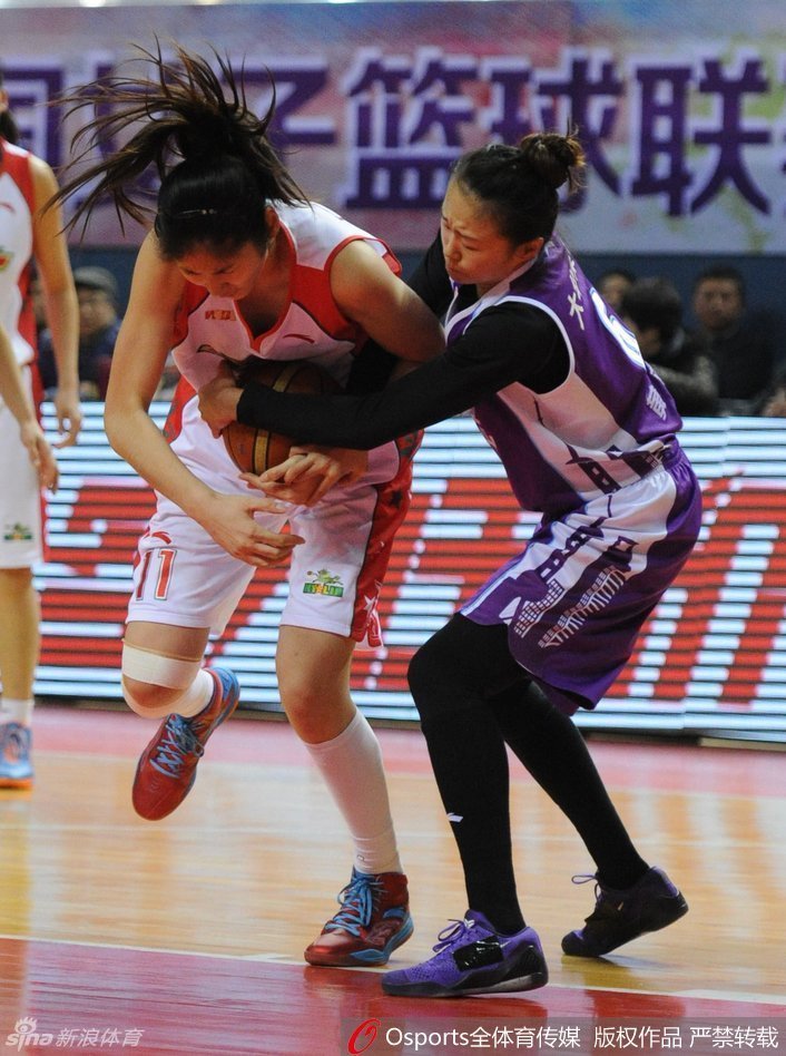 玛雅·摩尔运球强行突破，北京队两名防守球员夹击之下，她依然保持着身体的平衡，眼神中透露着对胜利的极度渴望，仿佛没有任何人能阻挡她前进的步伐。