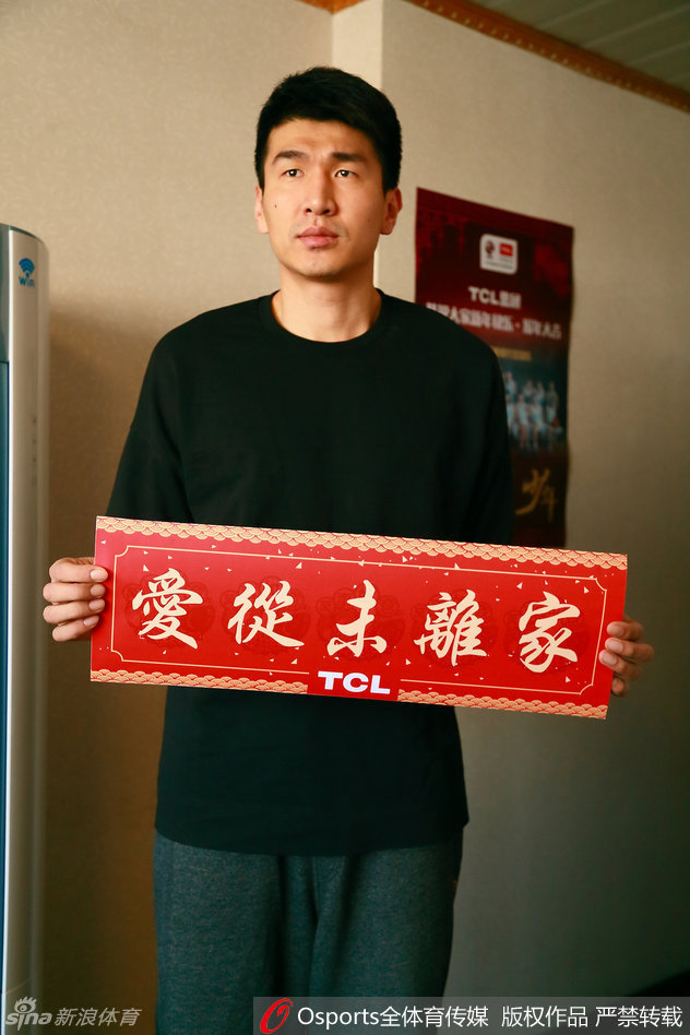 俞长栋在休息区被一位女球迷拦住合影，他双手自然垂下，脸上挂着略带羞涩又开心的笑容，眼神中透露出被球迷喜爱的满足感。