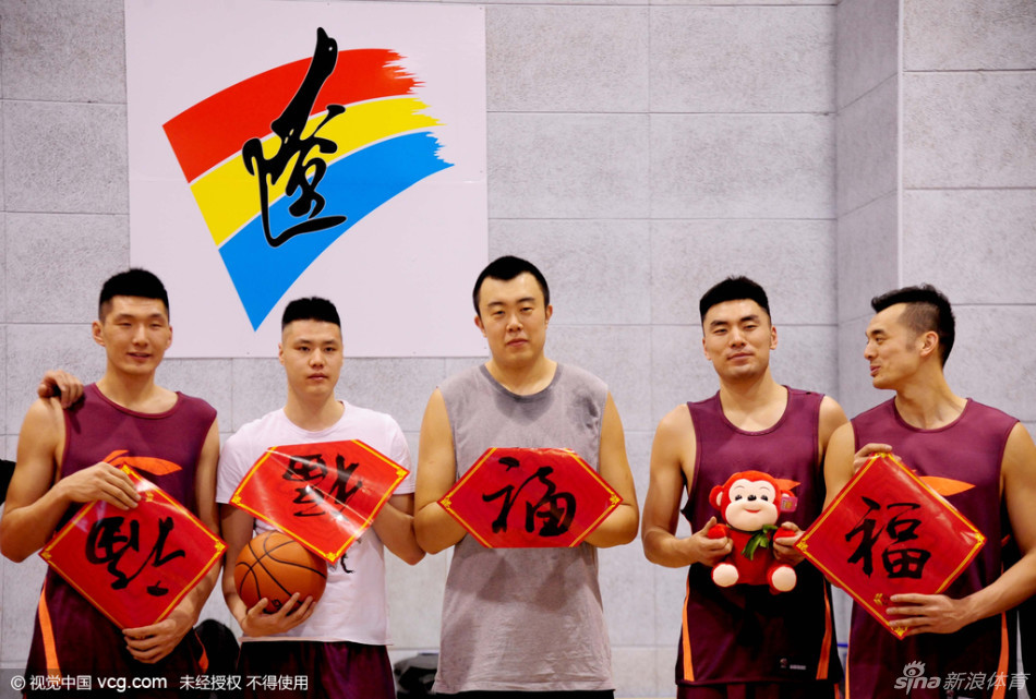 郭艾伦手持红色新春卡片，对着镜头俏皮地眨眼，左侧鬓角的13号发型清晰可见，笑容里透着一股大男孩的顽皮与自信。