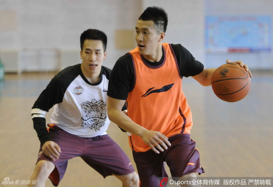 郭爸在训练中客串组织者，他双手稳稳持球，眼神犀利，正在给年轻球员们做传球示范。