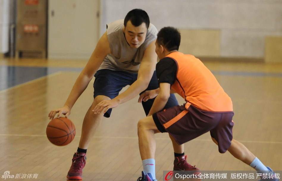 训练间歇，郭艾伦和父亲并肩坐在场边，艾伦侧身认真听父亲说着什么，父子俩神情专注而亲密。