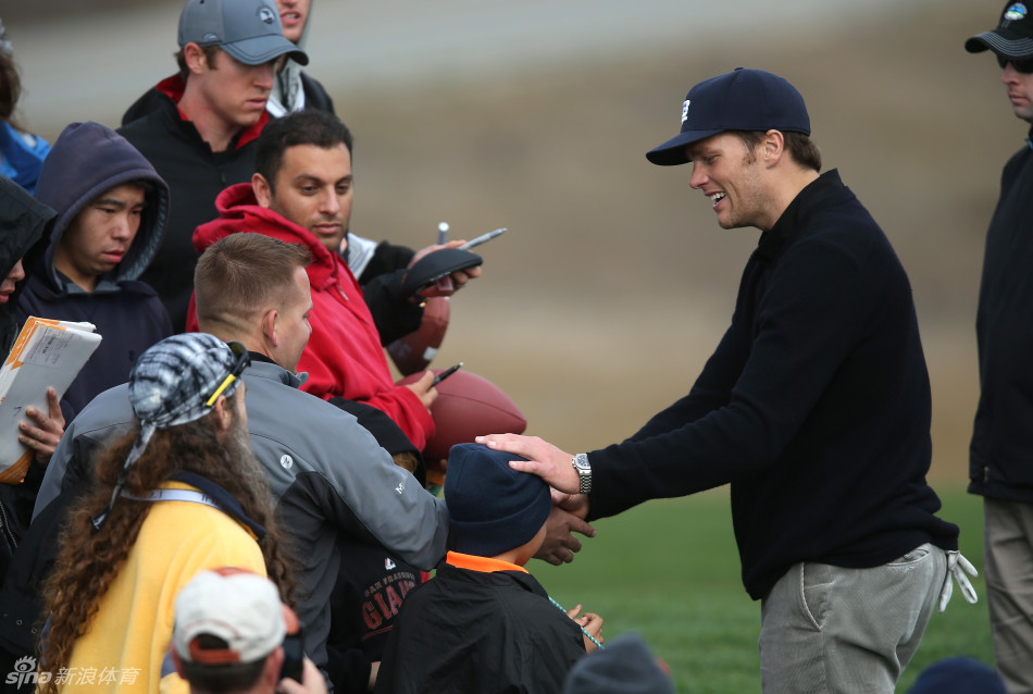 佩顿·曼宁在热烈的球迷包围中微笑着签名，展现橄榄球巨星的亲民魅力
