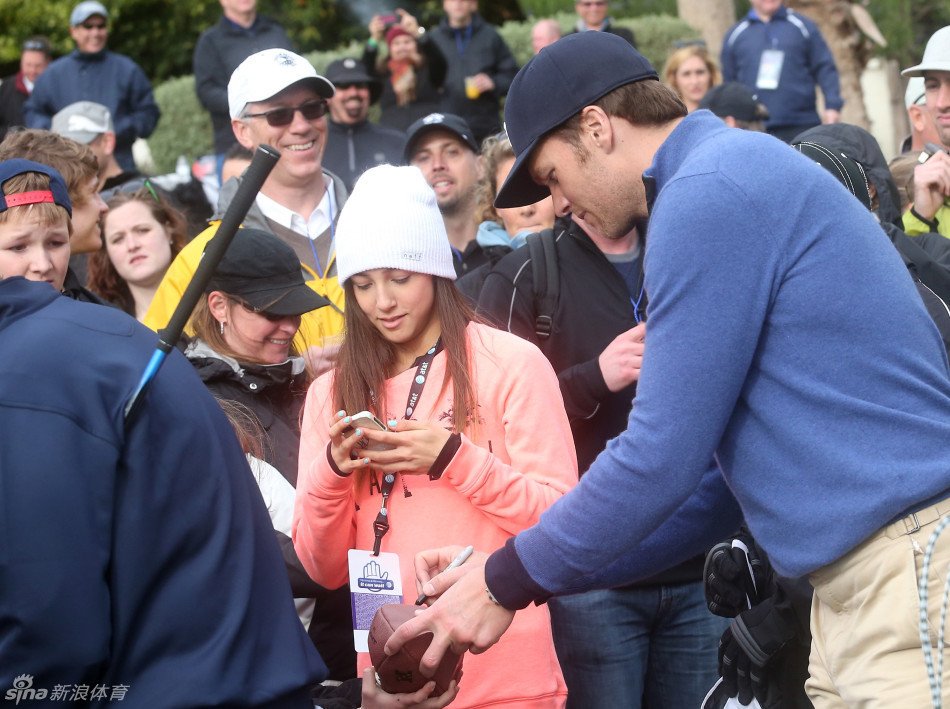 汤姆·布雷迪在练习果岭上与年轻球迷轻松互动，笑容灿烂毫无巨星距离感