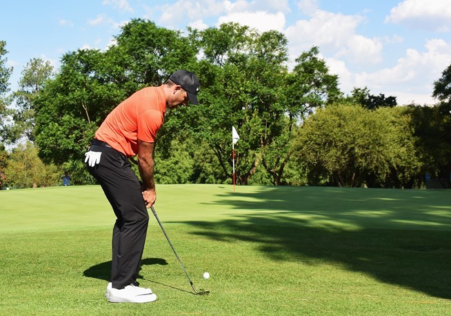 查尔-舒瓦泽尔在果岭边专注地观察球路，准备一记至关重要的切杆。