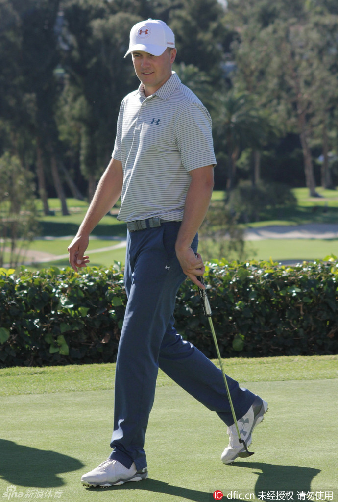 斯皮思与教练或伙伴并肩行走，一边用手指点着果岭地形，认真探讨推杆策略