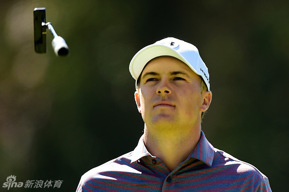 达斯汀·约翰逊在阳光下抬手示意，神情果决，尽显赛场指挥官风范