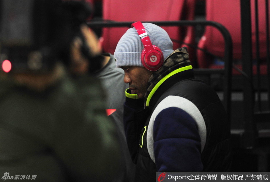 大外援莫里斯身穿灰色套头衫站在场边，神情严肃，他在内线需要面对布拉切和周琦的轮番冲击，眼神中透露出思索与坚定。