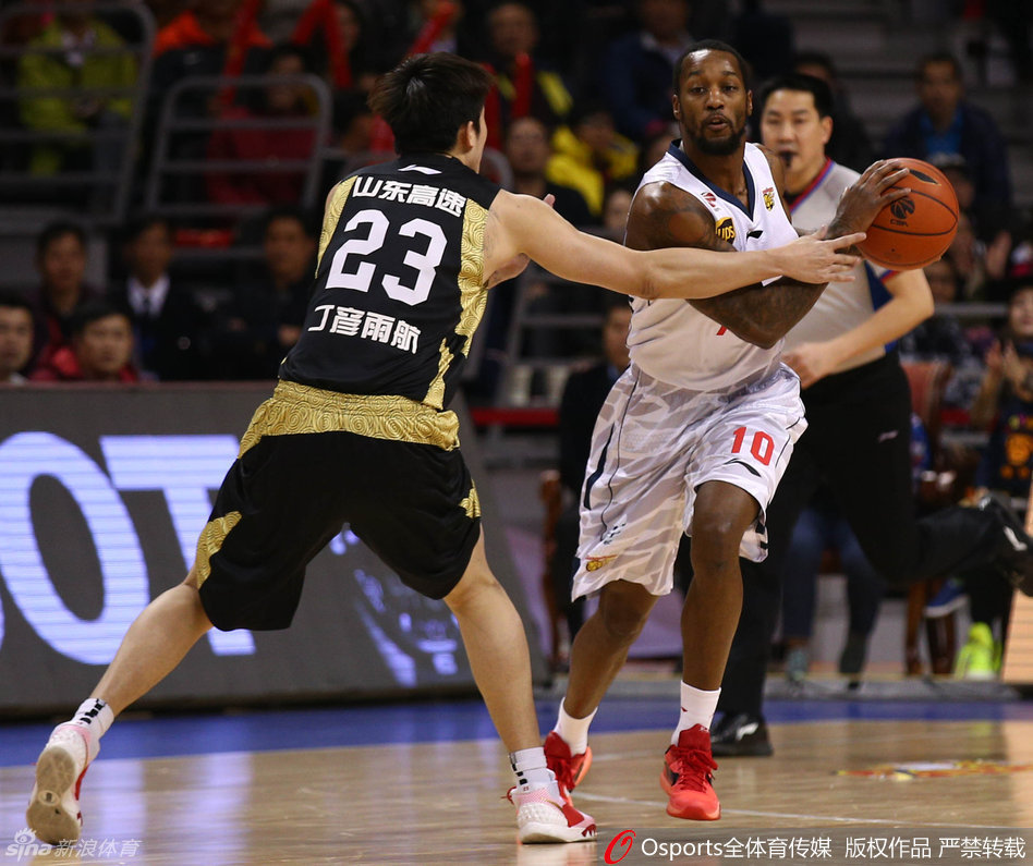 易建联在高位持球，面对防守做出三威胁姿势，随后突然启动突破分球，强大的个人牵制力吸引了两名防守球员包夹。