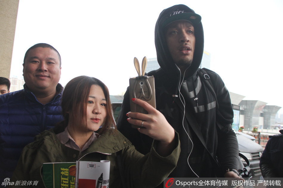 在候车大厅的休息区，比斯利坐在椅子上低头查看手机，身边是刚刚签过名的纪念品，而他的身后，仍有球迷依依不舍地守护着，不愿离去。