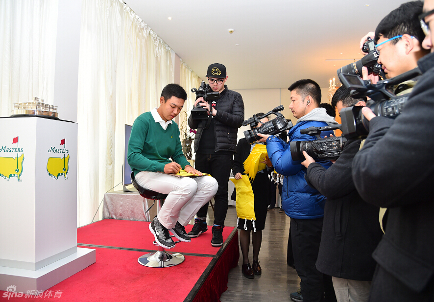 金诚在见面会现场专注地为热情的高尔夫球迷签名留念